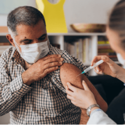 Hispanic Man Receiving Covid 19 vaccine